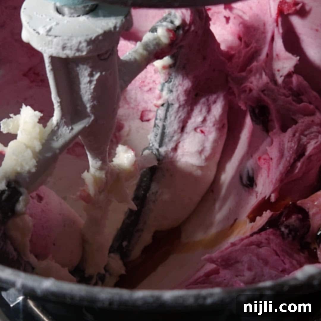 Chocolate Blueberry Delight 15 Berry buttercream frosting for a chocolate blueberry cake being mixed in a stand mixer, showing its light purple color and creamy texture.