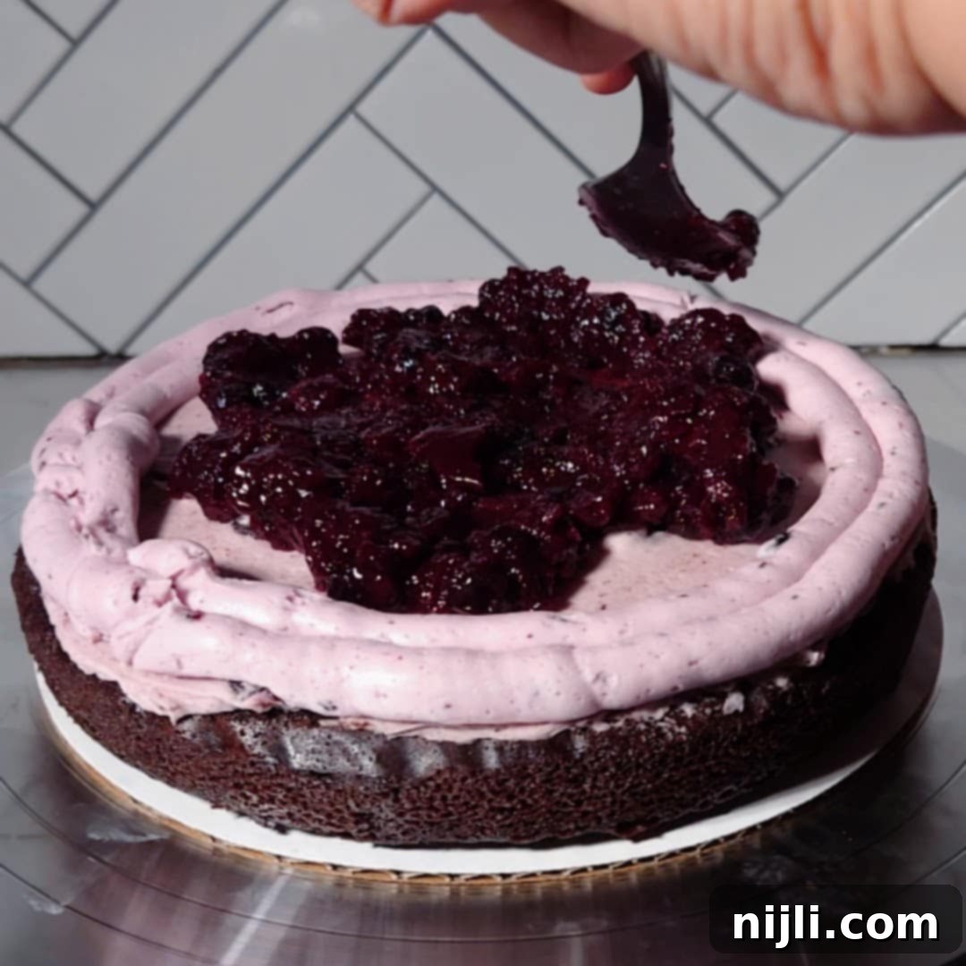 Chocolate Blueberry Delight 16 Assembling a chocolate blueberry cake with swirls of berry frosting and a generous layer of homemade blueberry filling.