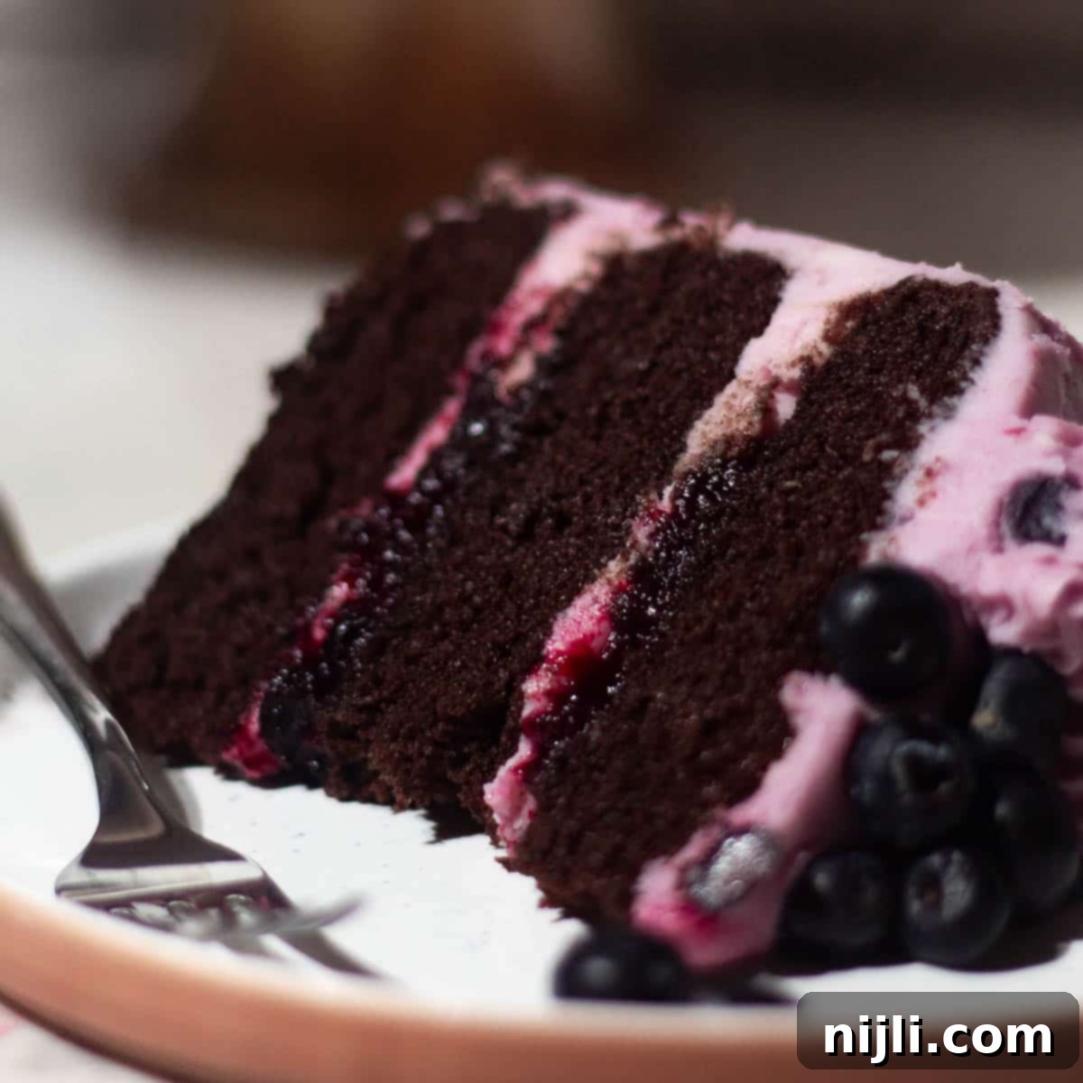 Chocolate Blueberry Delight 3 Chocolate blueberry cake with three layers of moist chocolate sponge, filled and frosted with blueberry buttercream and topped with fresh blueberries.