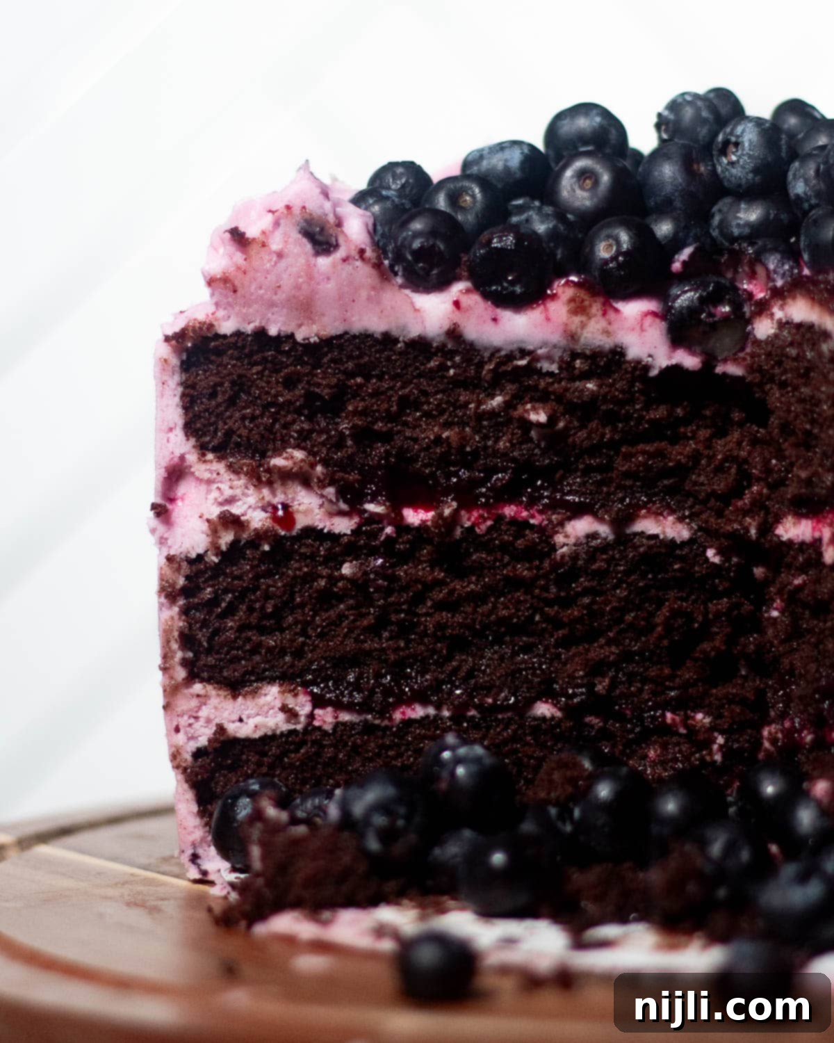 Chocolate Blueberry Delight 7 Chocolate blueberry cake with fresh blueberries on top and creamy berry frosting between thick chocolate layers.