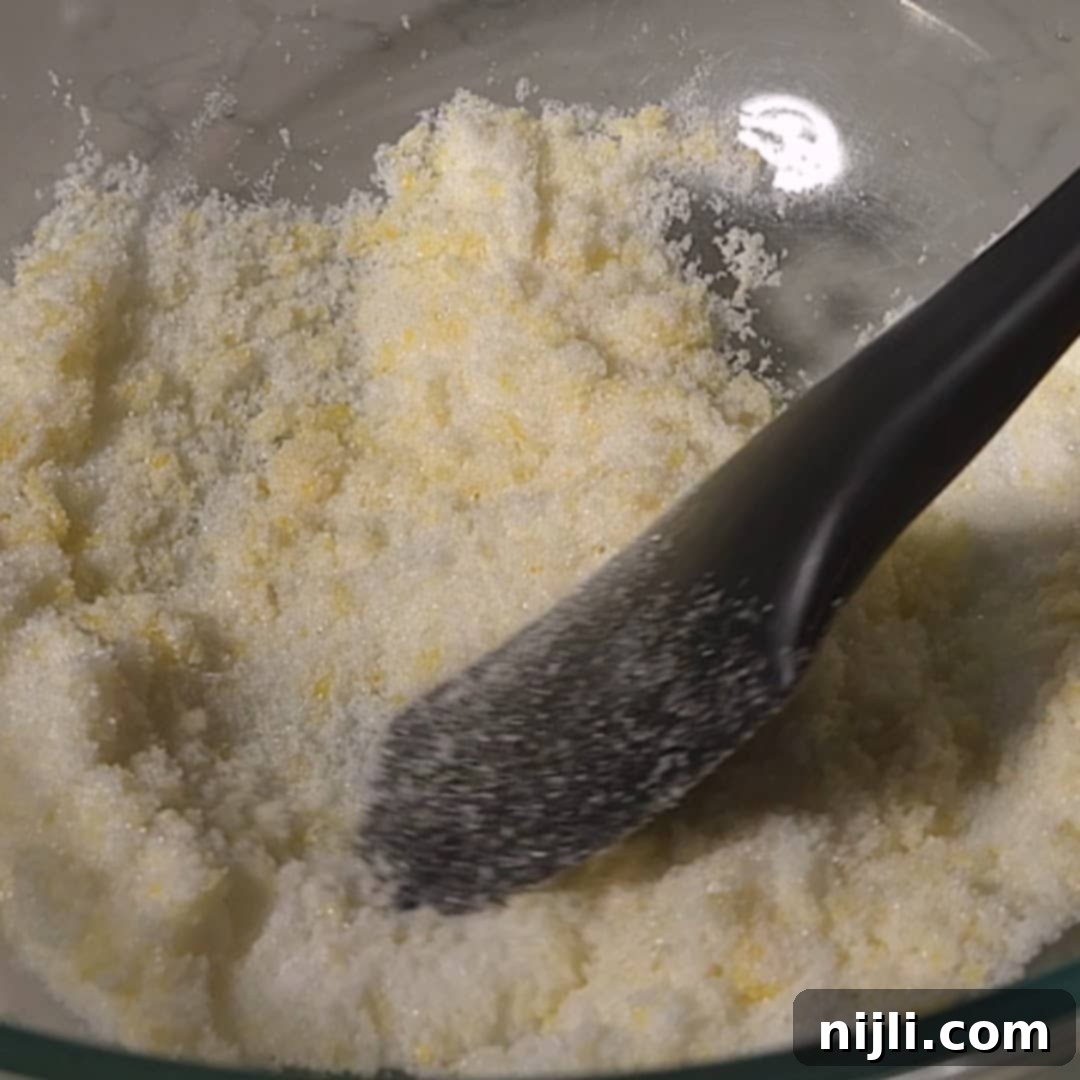 Sunny Lemon Blueberry Mascarpone Delight 7 Pressing sugar into lemon zest as the base of the lemon blueberry mascarpone cake recipe.