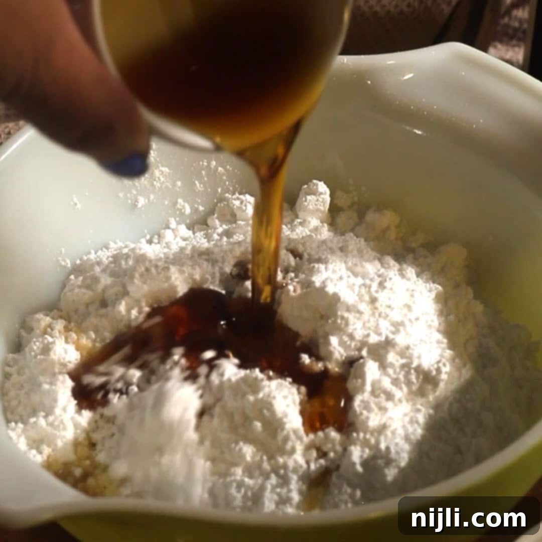 Spiced Pumpkin Perfection 14 Pouring maple syrup into a bowl of powdered sugar to make glaze for pumpkin spice donuts, with close-up focus on rich texture.