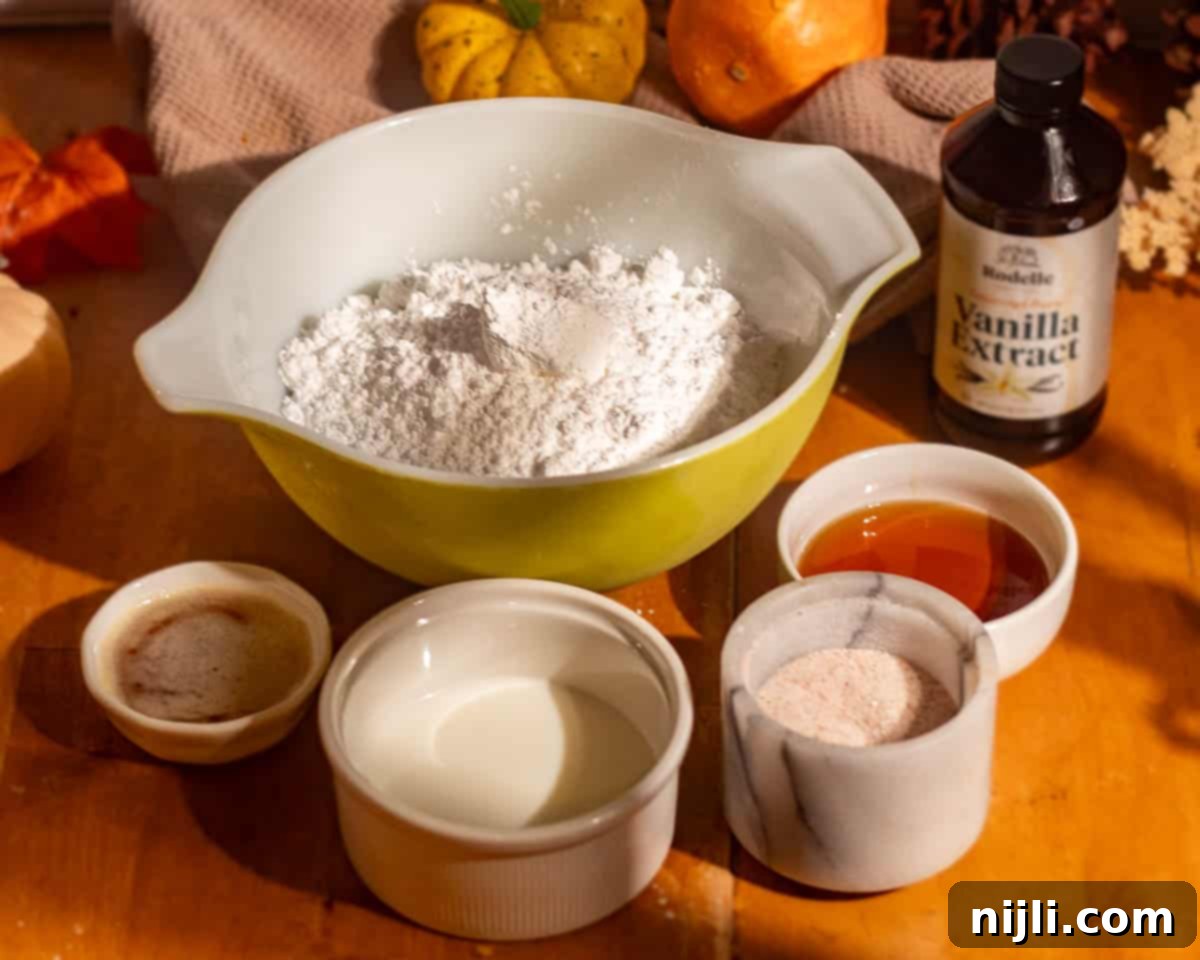 Spiced Pumpkin Perfection 6 Glaze ingredients for pumpkin spice donuts arranged in bowls, including powdered sugar, milk, maple syrup, vanilla extract, and cinnamon sugar, surrounded by mini pumpkins.