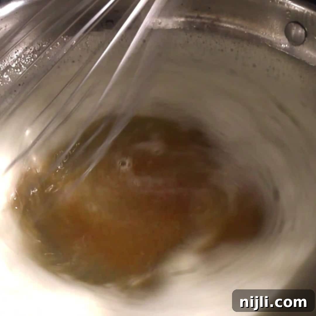 Spiced Pumpkin Perfection 8 Brown butter bubbling in a saucepan, captured mid-whisk, as a key flavor base for pumpkin spice donuts.