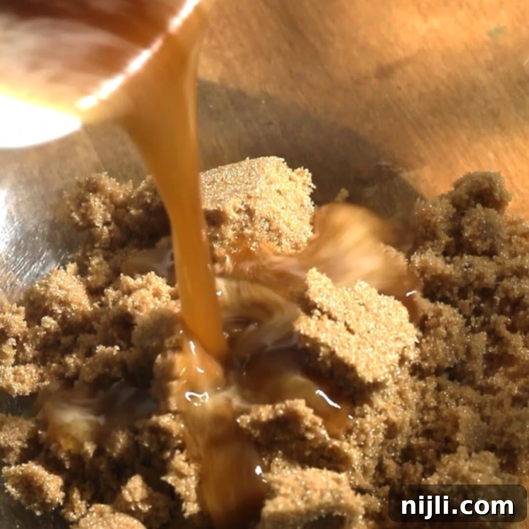 Spiced Pumpkin Perfection 10 Brown butter being poured into a bowl of brown sugar for pumpkin spice donuts, showing caramelization up close.