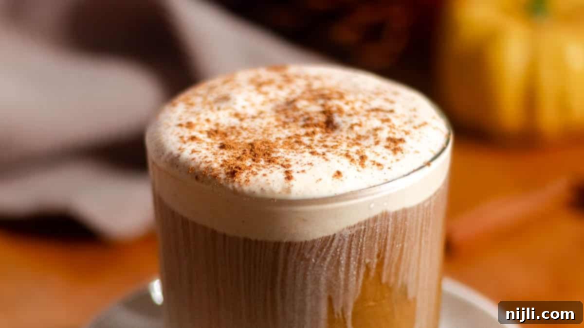Starbucks Style Pumpkin Cold Foam 5 Close-up of iced coffee topped with thick pumpkin cold foam and dusted with cinnamon.
