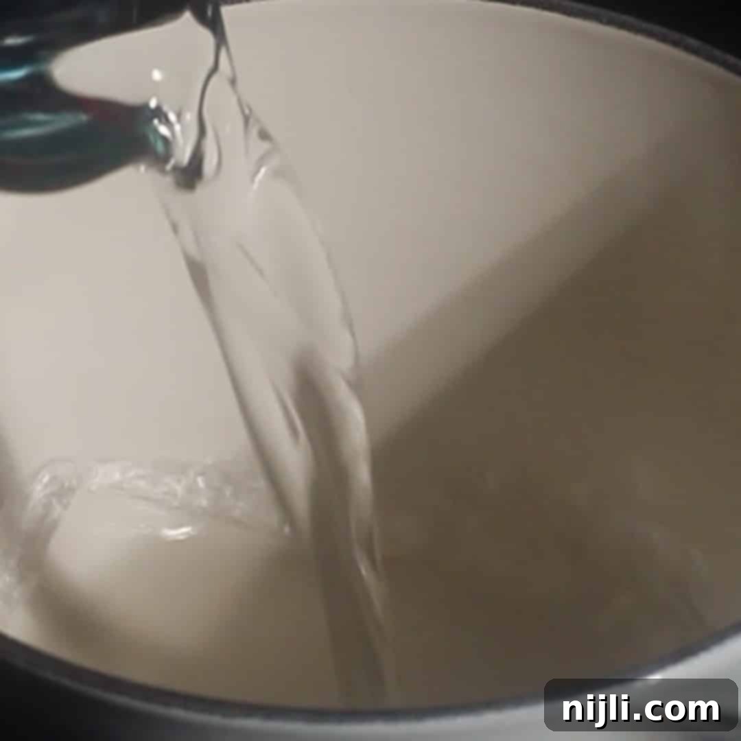 Starbucks Style Pumpkin Cold Foam 6 Water being poured into a saucepan to start pumpkin cold foam syrup recipe.