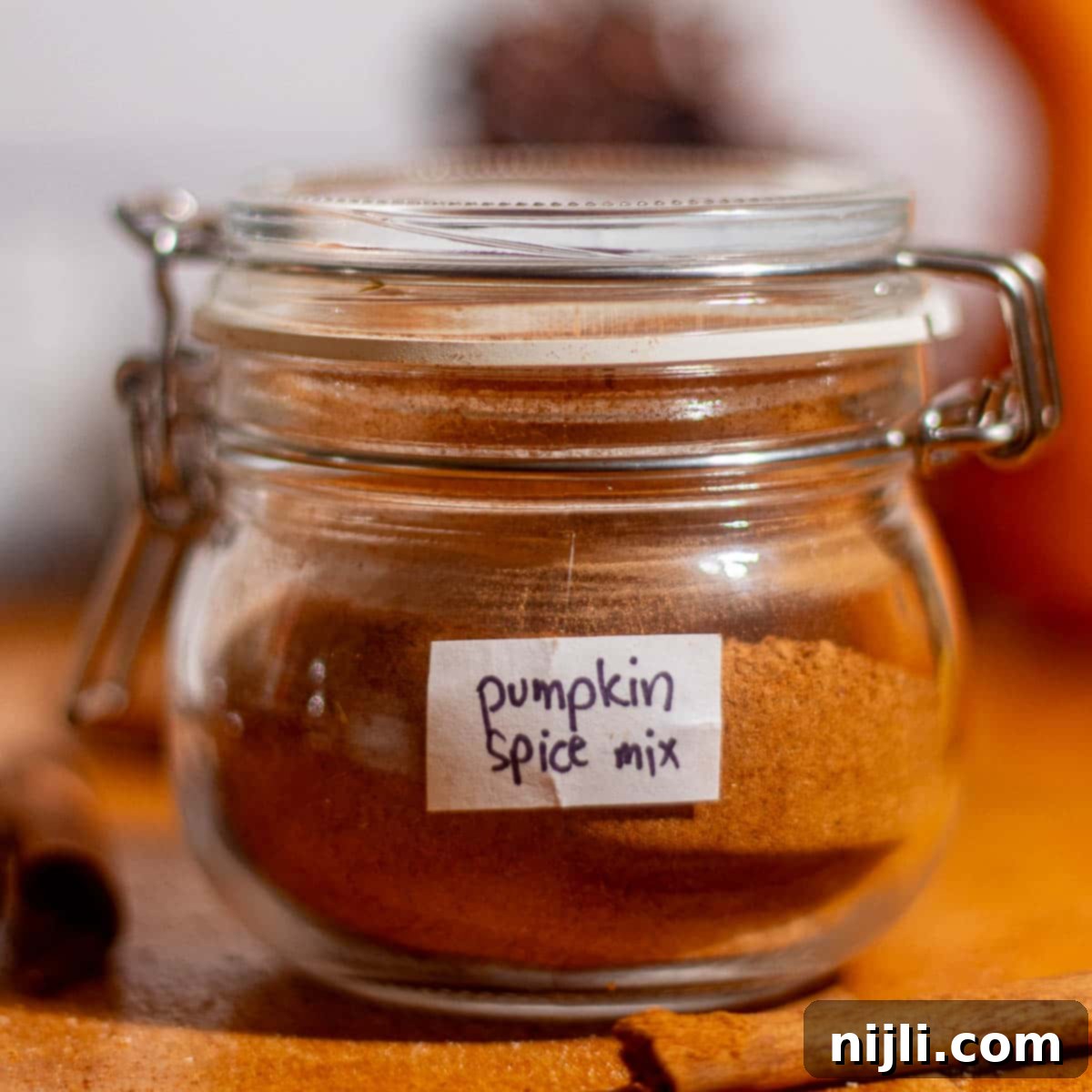 Spiced Pumpkin Harmony 3 Small labeled jar of homemade pumpkin spice mix on a rustic wooden counter.