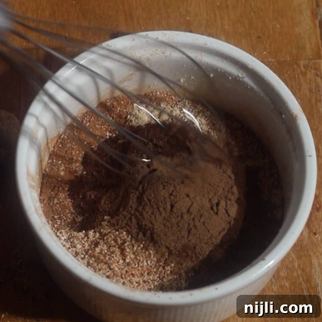 Spiced Pumpkin Harmony 8 Whisk mixing cinnamon, ginger, nutmeg, cloves, and allspice to create a uniform pumpkin spice blend.