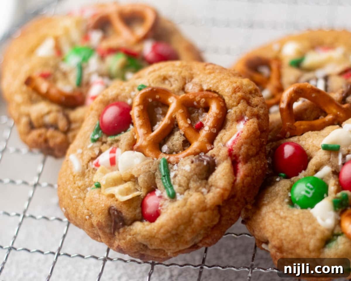 The Everything Cookie 13 Festive Christmas kitchen sink cookies with red and green M&Ms, pretzels, white chocolate, and sprinkles for holiday cookie trays.