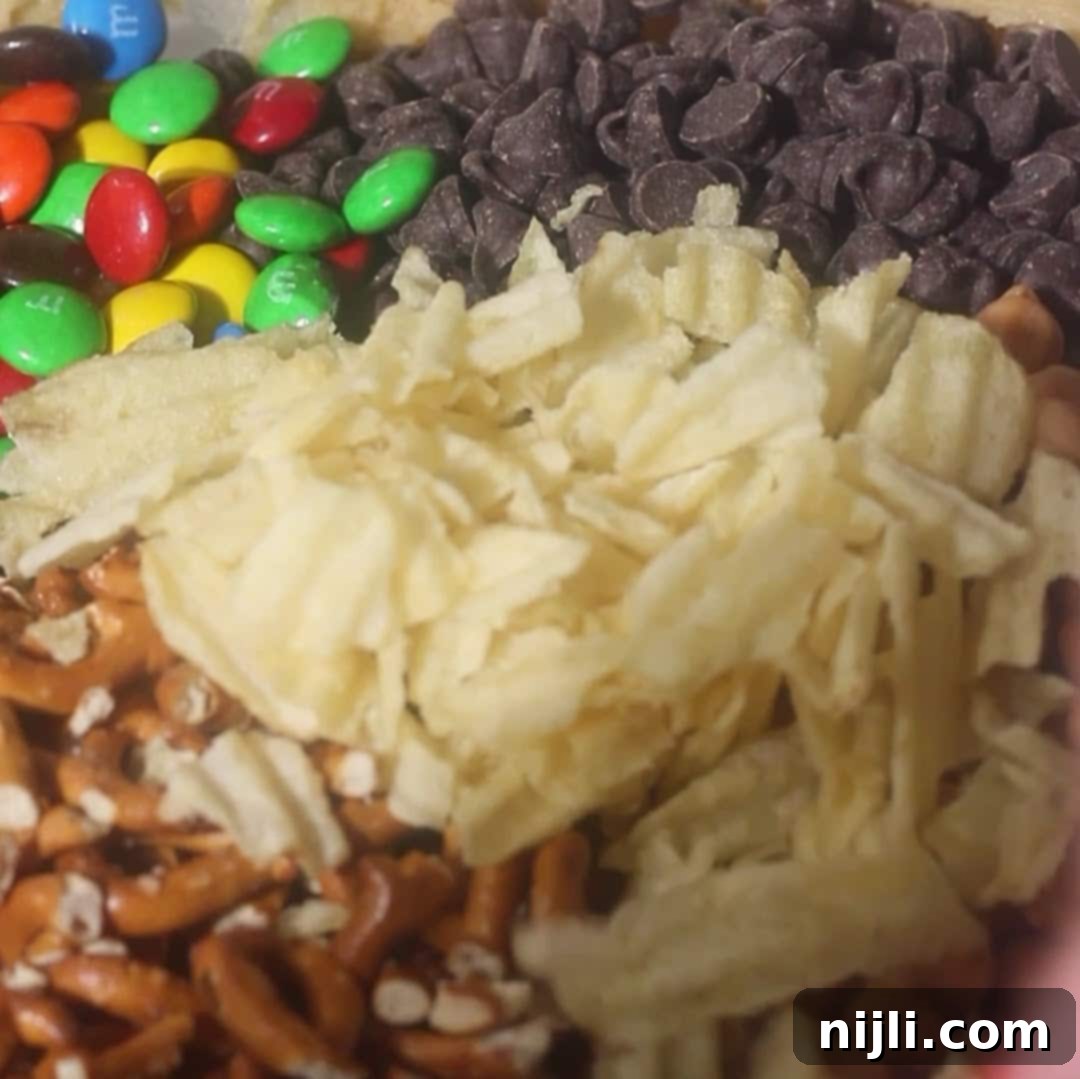 The Everything Cookie 10 Bowl filled with colorful M&Ms, chocolate chips, pretzels, and potato chips for kitchen sink cookie mix-ins.