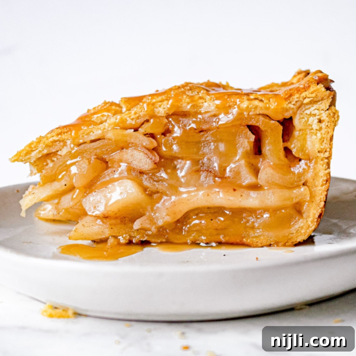 Decadent Deep Dish Caramel Apple Pie 5 Side view of slice of deep dish caramel apple pie