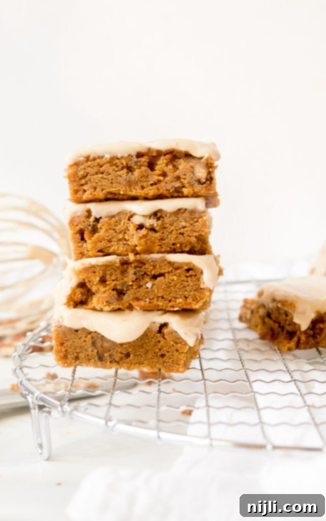 Spiced Pumpkin Blondies with Apple Cider Drizzle 3 Delicious pumpkin blondie bars with apple cider glaze on a cooling rack