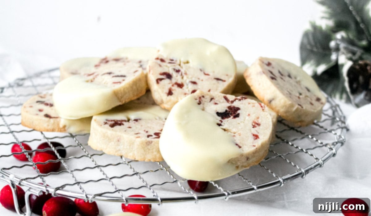 Cranberry White Chocolate Shortbread Delights 6 Multiple cranberry white chocolate shortbread cookies cooling on a wire rack after baking.