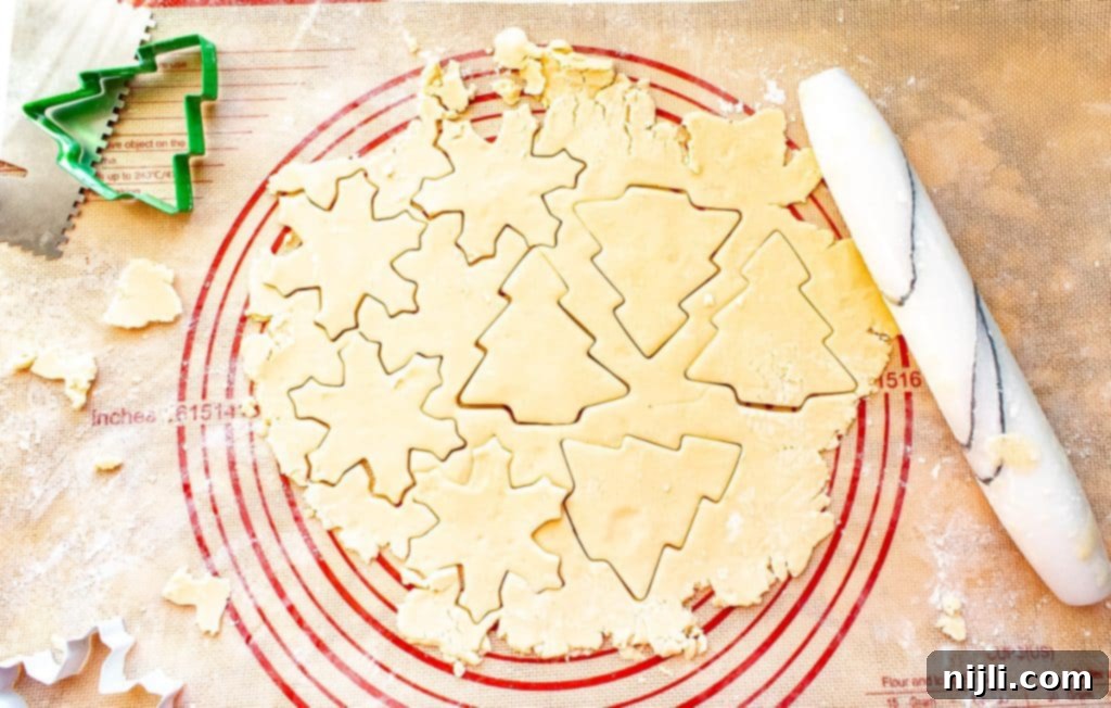 Perfectly Shaped Sugar Cookies 5 Sugar cookie dough cut into shapes with cookie cutters on a pastry mat
