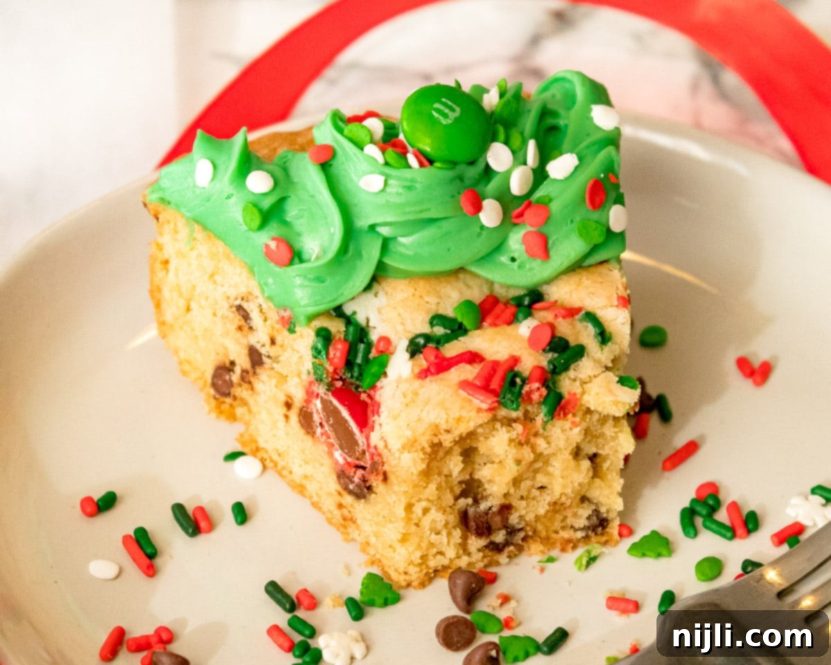 Festive Christmas Cookie Cake 5 A perfectly baked slice of Christmas Cookie cake with a bite taken out, showing its moist interior and chocolate chips.