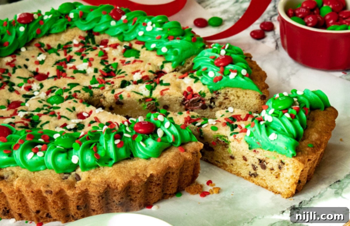 Festive Christmas Cookie Cake 7 Side view of a decorated Christmas cake with a slice cut out, ready to be served.