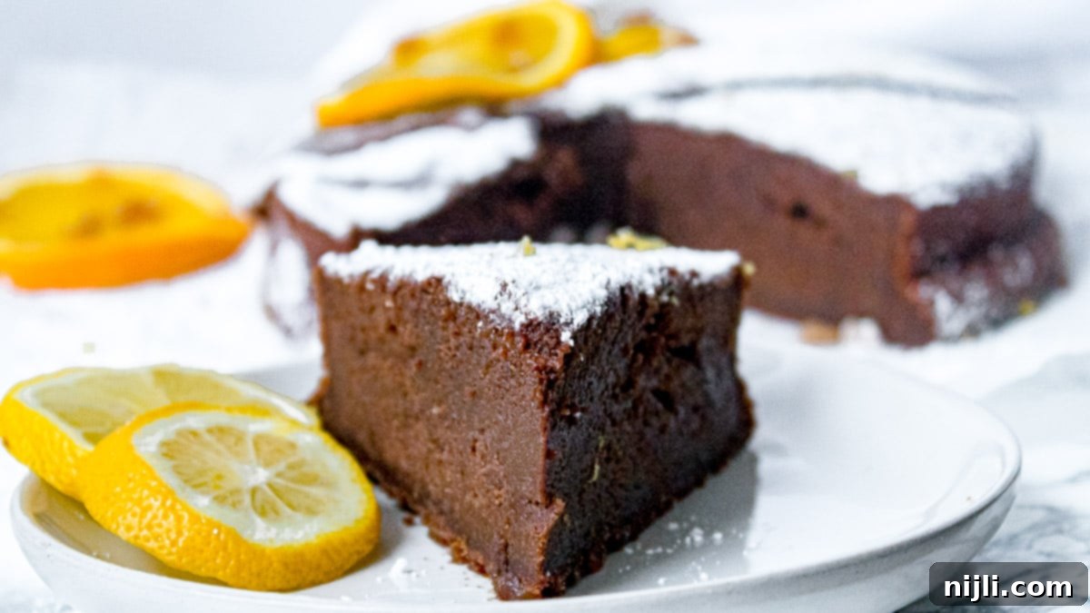 Decadent Chocolate Olive Oil Cake with Candied Ginger 3 A single slice of moist dark chocolate olive oil cake on a white plate, highlighting its rich color and inviting texture.