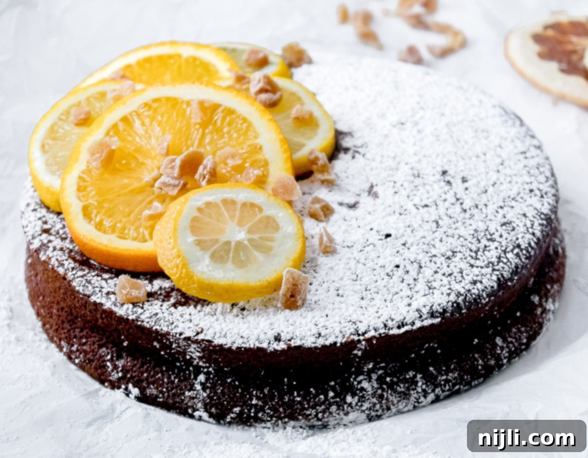Decadent Chocolate Olive Oil Cake with Candied Ginger 5 A whole chocolate olive oil cake, lightly dusted with powdered sugar, ready for serving.