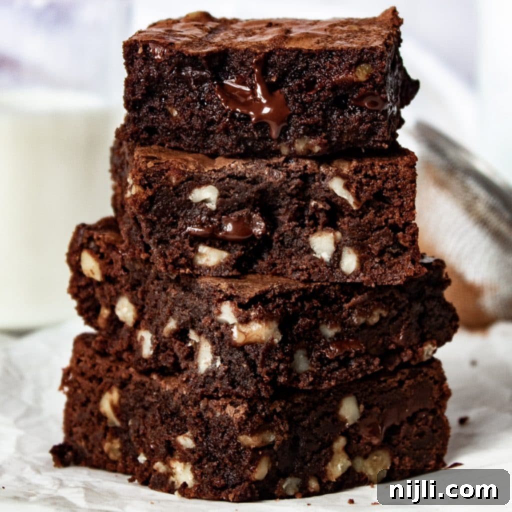 Gooey Chocolate Walnut Brownies 2 stack of dark chocolate walnut brownies on a counter.