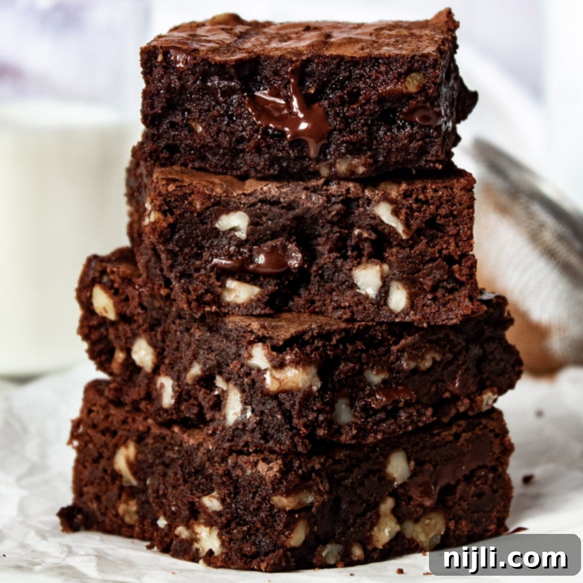 Gooey Chocolate Walnut Brownies 11 stack of dark chocolate walnut brownies on a counter.