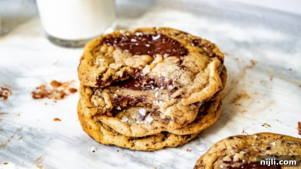Perfect Brown Butter Chocolate Chip Cookies 3 Small batch chocolate chip cookies stacked on a parchment paper sheet.