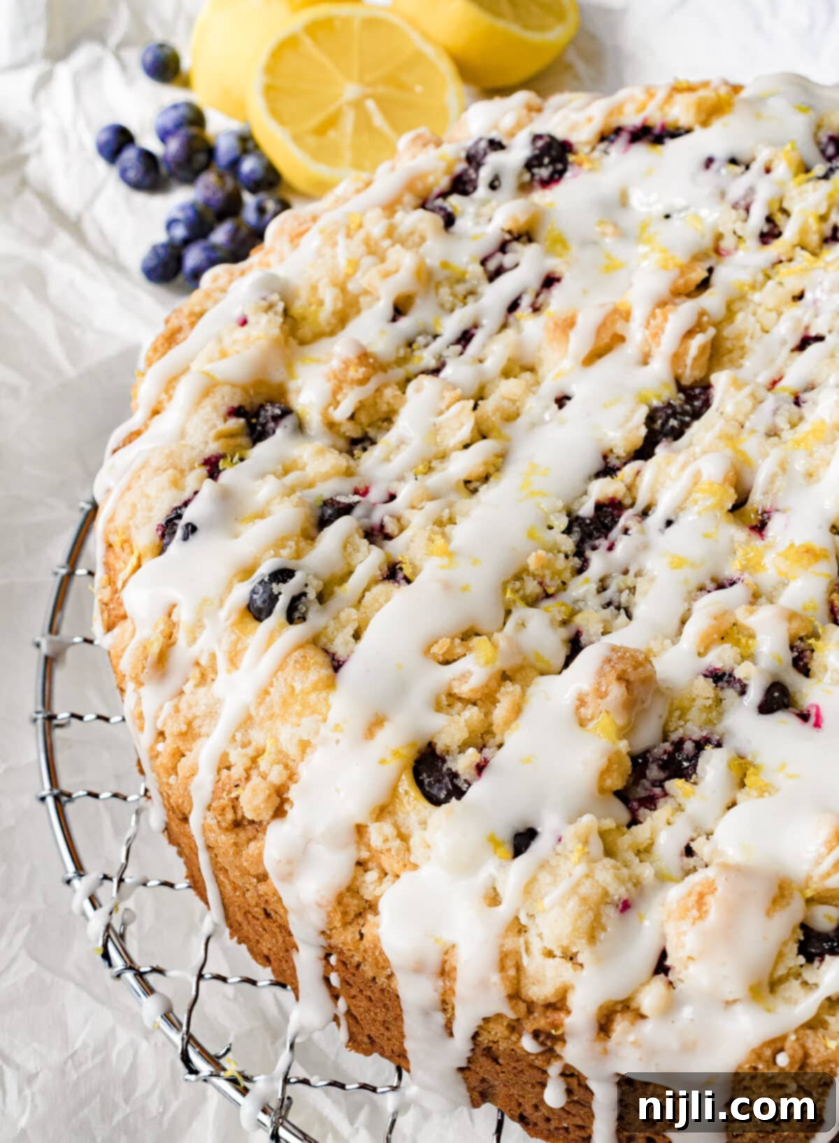 iced cream cheese blueberry cake on a rack