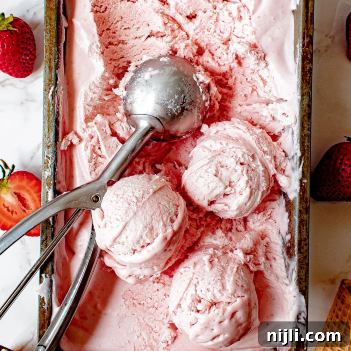 Easy Strawberry Ice Cream 2 no churn strawberry ice cream in a container with scoops