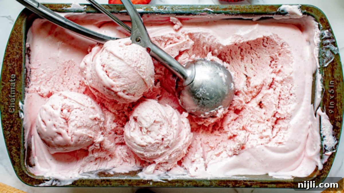Easy Strawberry Ice Cream 4 no churn strawberry ice cream in a container with scoops