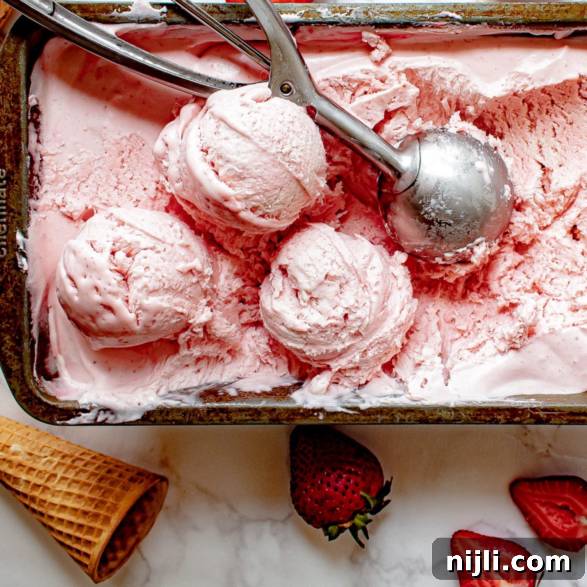 Easy Strawberry Ice Cream 6 no churn strawberry ice cream in a container with scoops