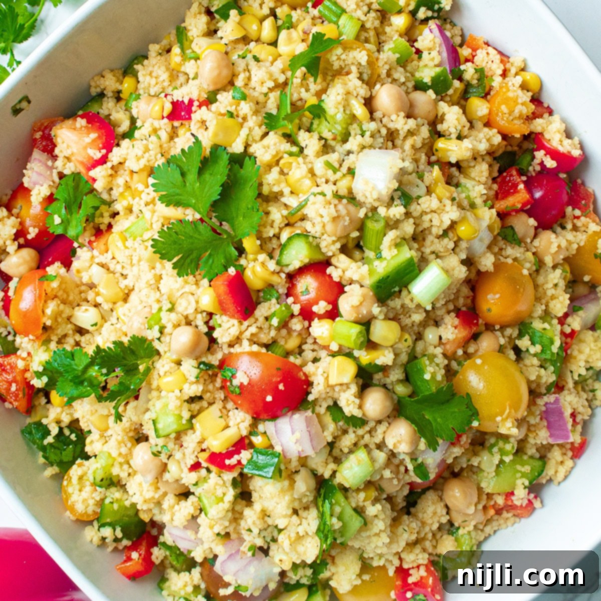 Vibrant Vegan Couscous & Chickpea Salad 2 A beautifully arranged vegan couscous salad in a rustic bowl, showcasing chickpeas, charred corn, and colorful fresh vegetables.