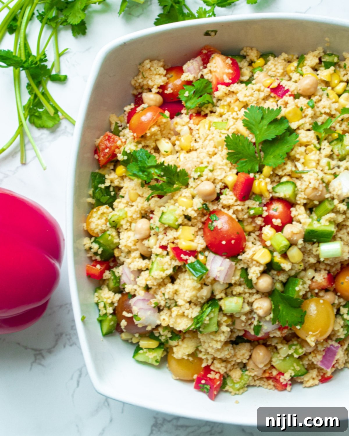 Vibrant Vegan Couscous & Chickpea Salad 3 A close-up shot of a vegan couscous bowl, highlighting the texture of the couscous and the vibrant colors of the vegetables and chickpeas.