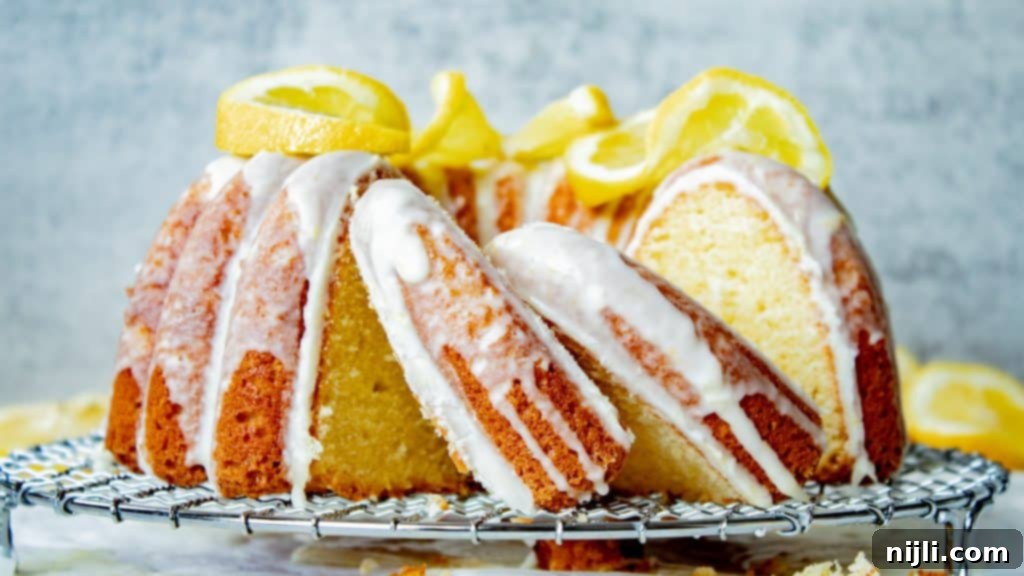 Sunshine Lemon Sour Cream Cake 4 lemon sour cream pound cake on a wire rack with slices cut out, showing its moist crumb
