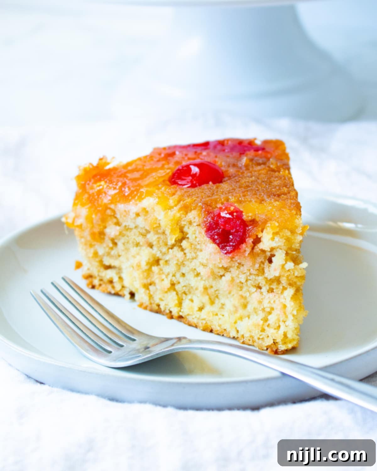 A beautiful slice of vegan pineapple upside down cake ready to be served