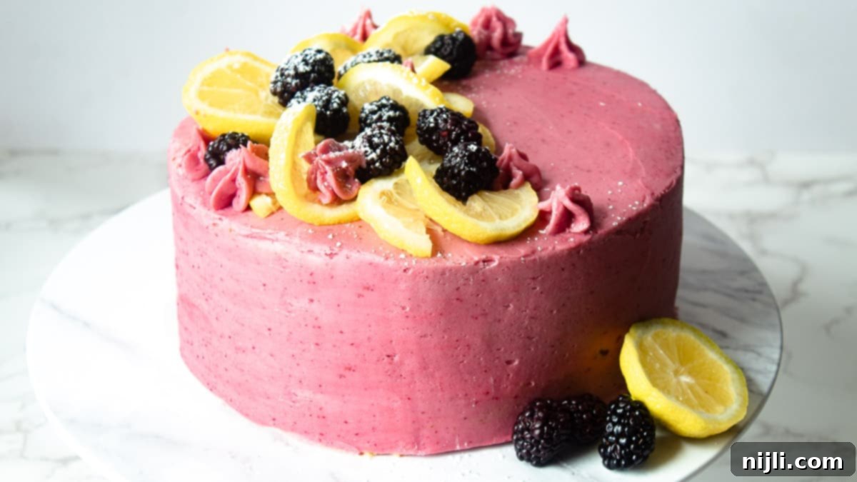 Sunshine Lemon Blackberry Delight 3 Beautifully frosted and decorated easy blackberry cake on a cake stand, ready to be served.