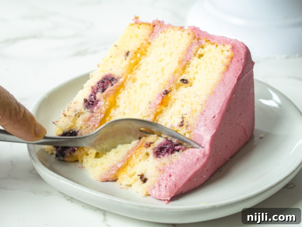 A beautifully presented slice of lemon and blackberry cake on a plate, ready to be enjoyed.