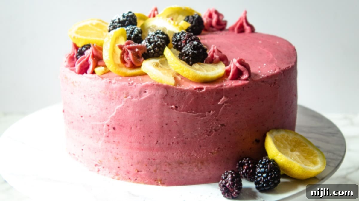 A delicious and beautifully decorated easy blackberry cake on a stand, with rich frosting.