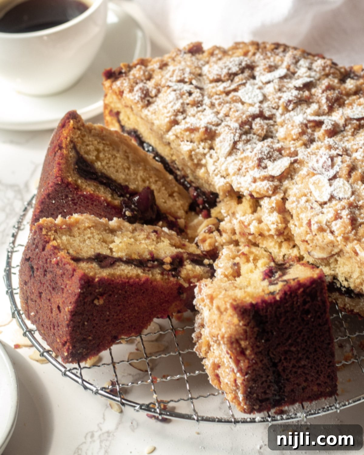 A tray filled with slices of cinnamon cherry coffee cake, featuring its signature crumb topping and juicy cherry filling peeking through, highlighting its delicious texture.