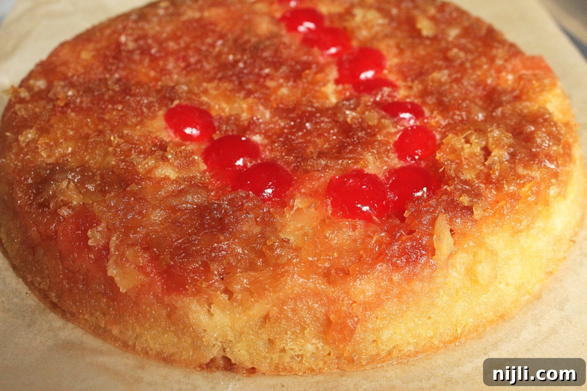 Sunny Skillet Pineapple Flip 2 Delicious pineapple upside down cake in a cast iron skillet, garnished with maraschino cherries and pineapple slices, ready to be served.