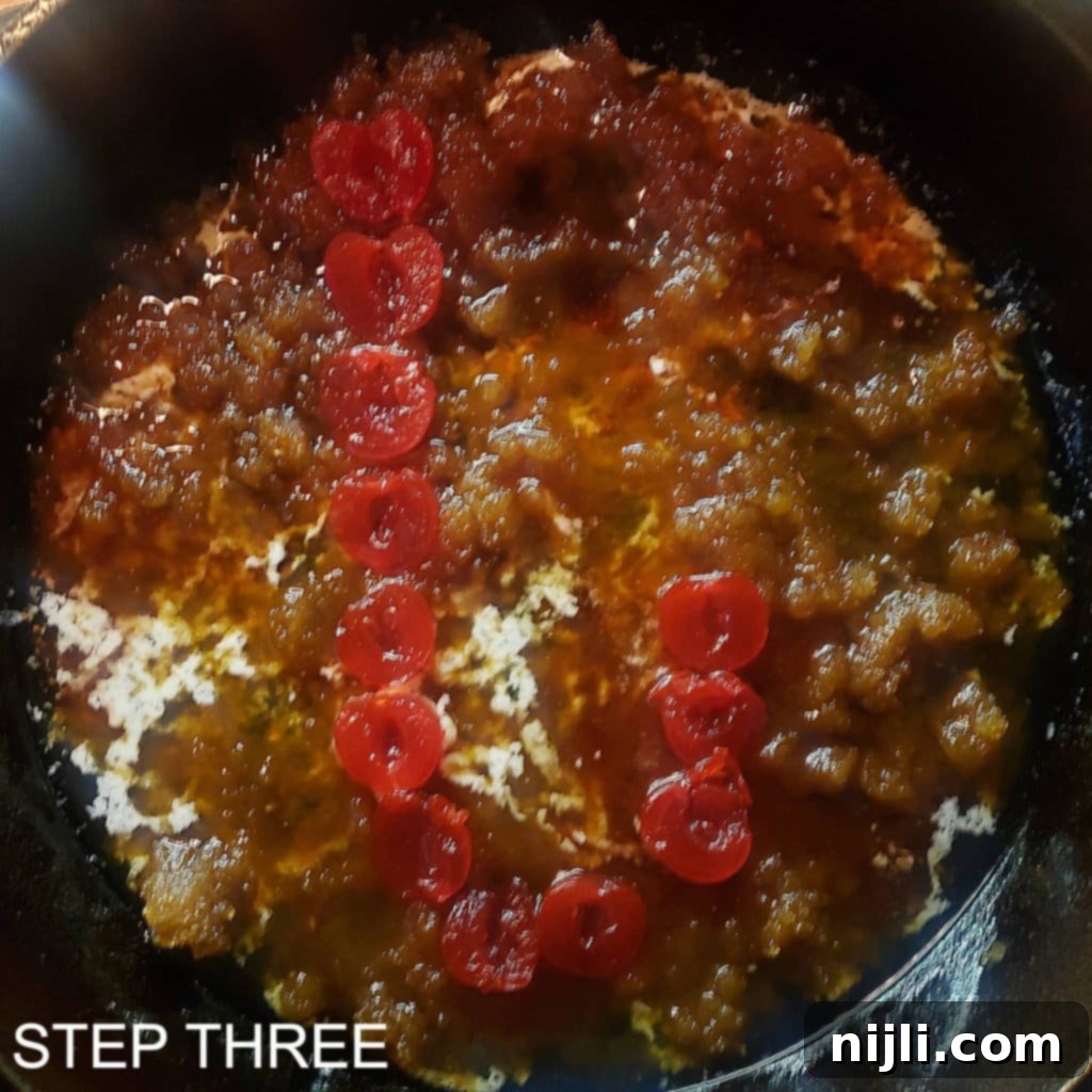 Sunny Skillet Pineapple Flip 6 Maraschino cherry halves arranged in a 'J' shape on the brown sugar layer in a cast iron skillet.