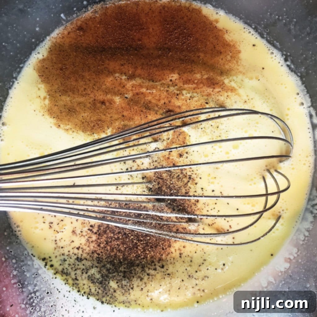 Decadent Bacon, Gruyère, Leek and Asparagus Quiche 6 Whisking eggs, milk, and cream for the smooth quiche custard filling | Chenée Today