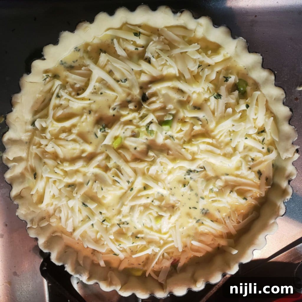 Decadent Bacon, Gruyère, Leek and Asparagus Quiche 10 Pouring the creamy egg custard mixture over the quiche filling | Chenée Today