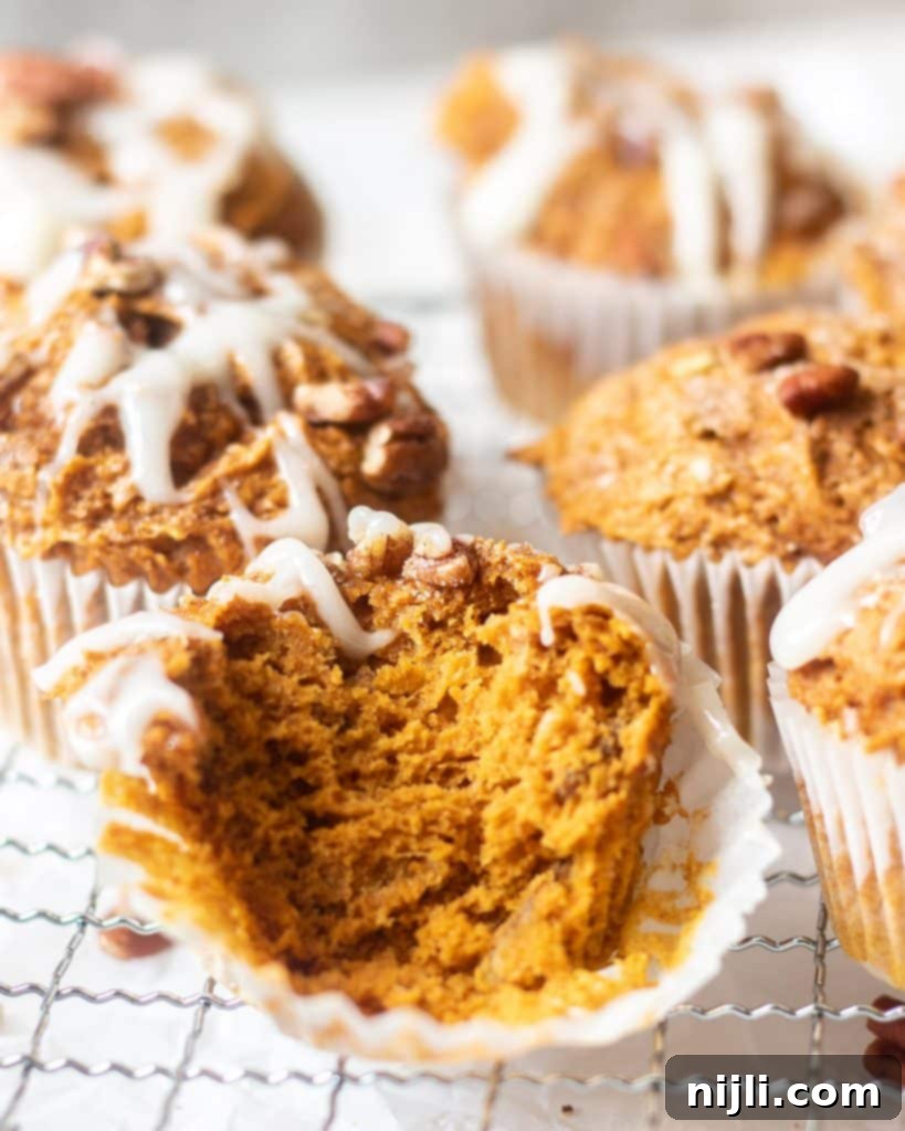 Effortless 3 Ingredient Pumpkin Muffins 5 pumpkin muffins, one with a bite taken out of it
