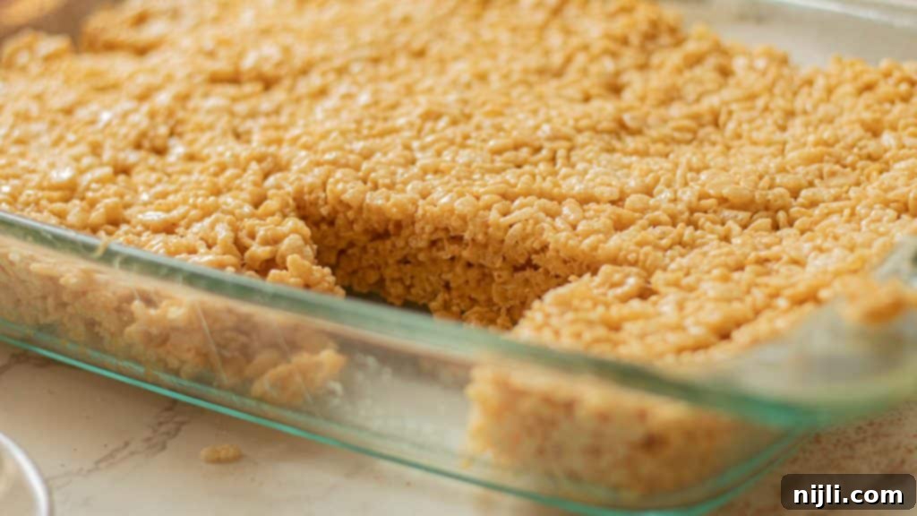 Peanut Butter Krispie Bars 3 A baking pan filled with freshly made peanut butter Rice Krispie treats, ready for cooling and cutting.