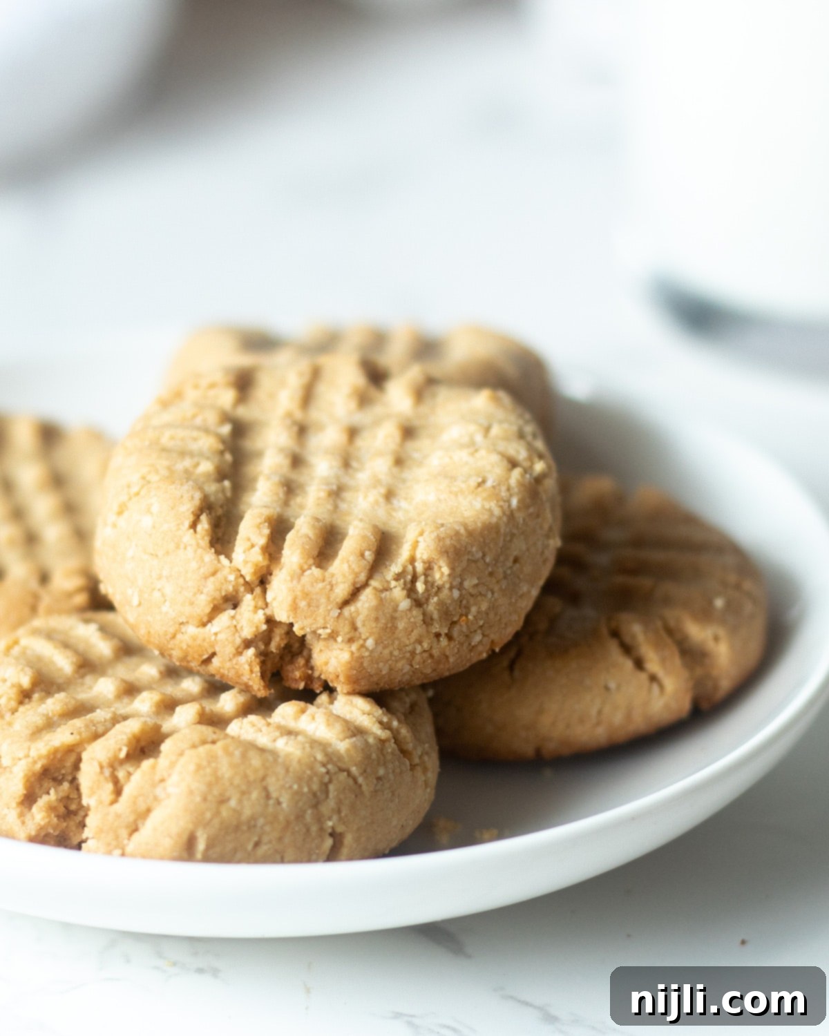 Delicious Almond Flour Peanut Butter Cookies 7 almond flour peanut butter cookies on a plate, showcasing their dense texture