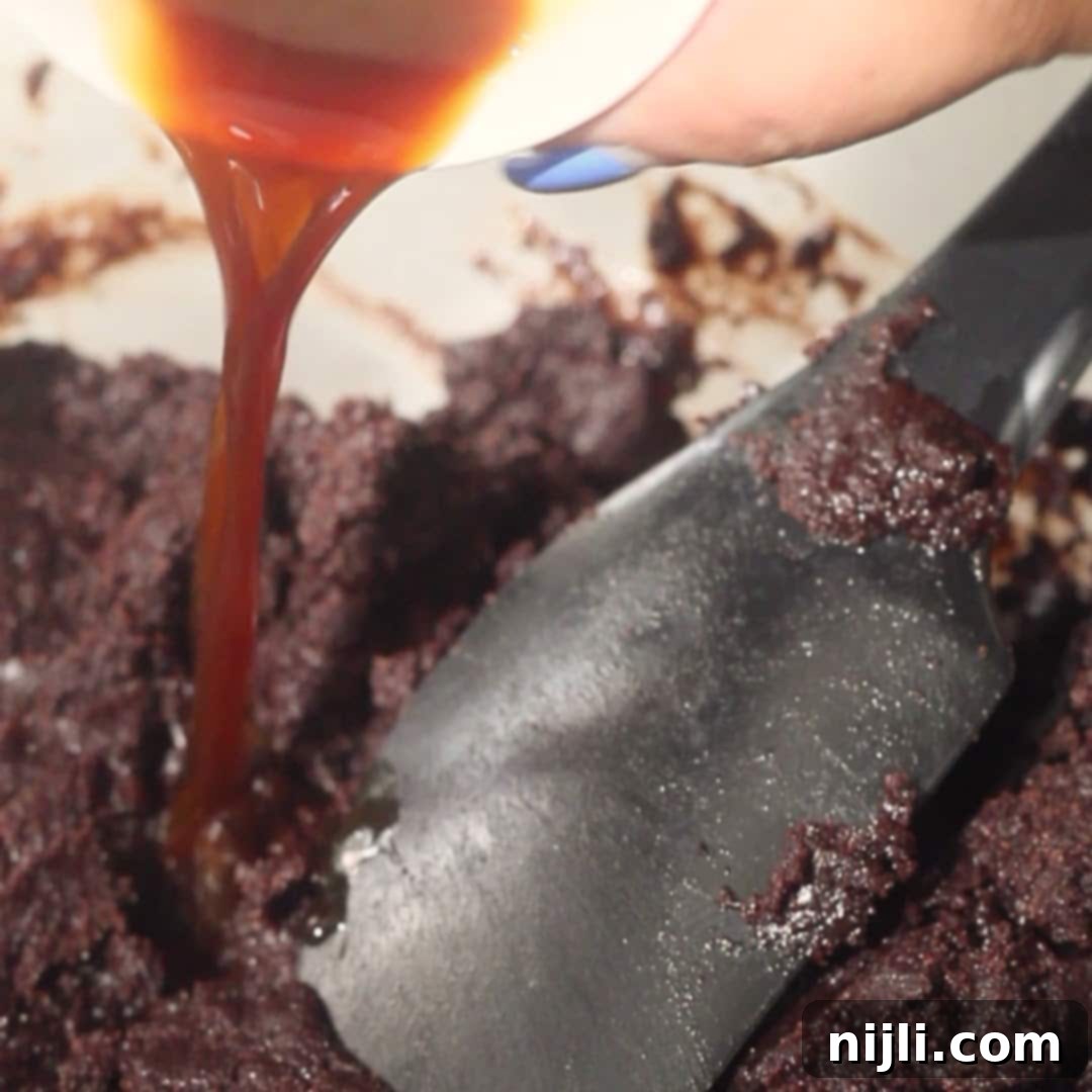Pouring vanilla into the cake batter to enhance the flavor of the chocolate mousse cake.