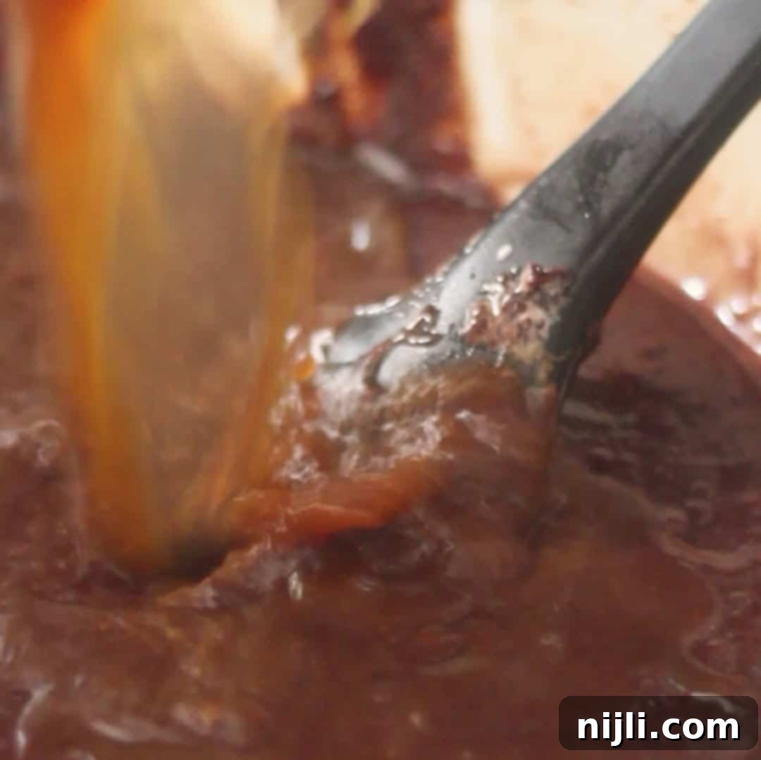 Pouring hot coffee into the cake batter to enhance the flavor of the chocolate mousse cake.