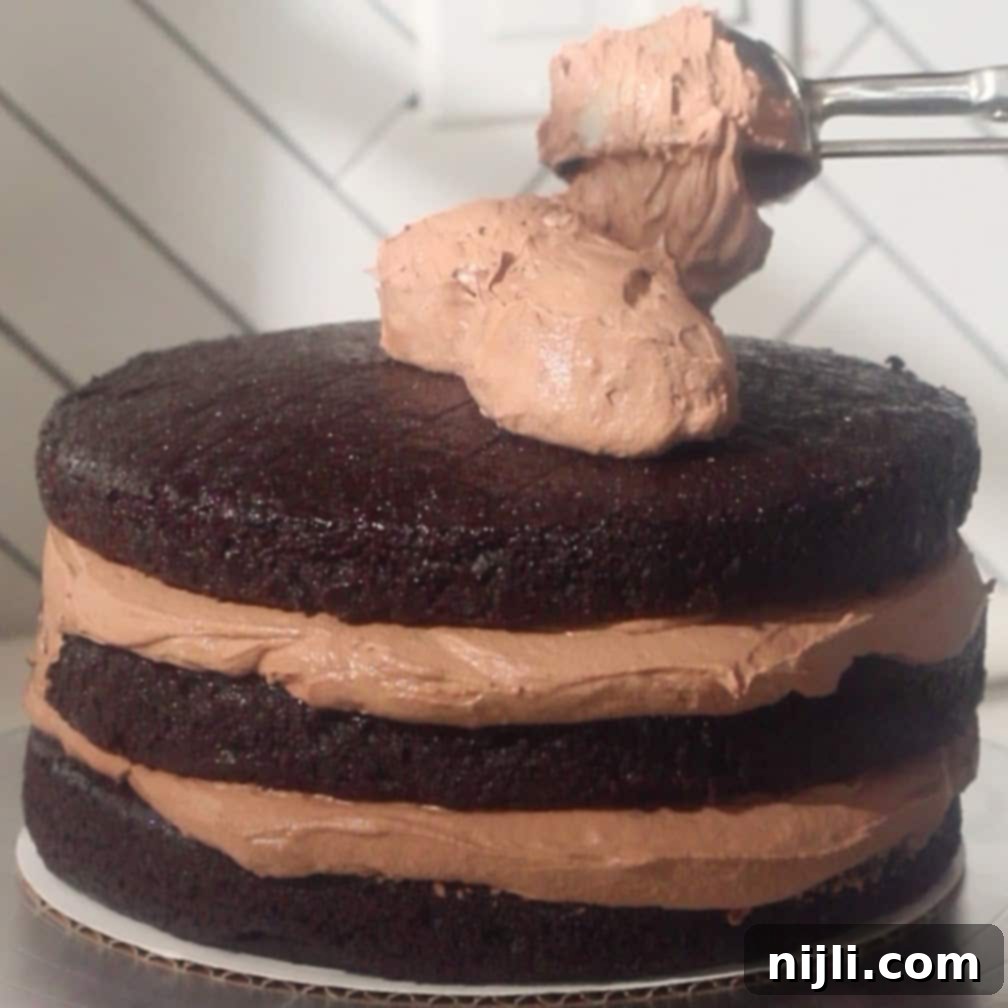 Layering thick chocolate mousse filling between moist chocolate cake layers.