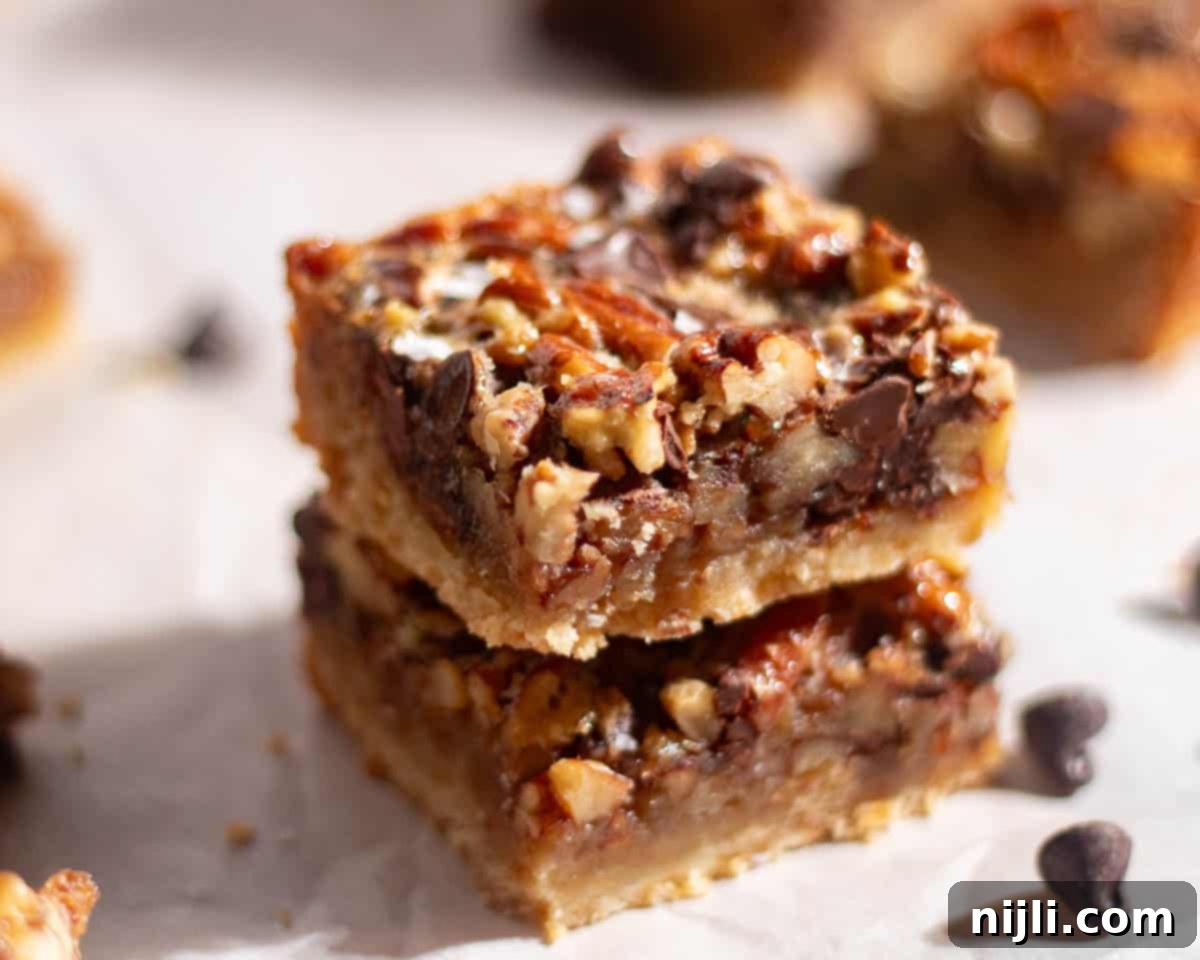 Close-up of pecan chocolate bars showing caramelized pecans and chocolate chunks baked into a golden crust.