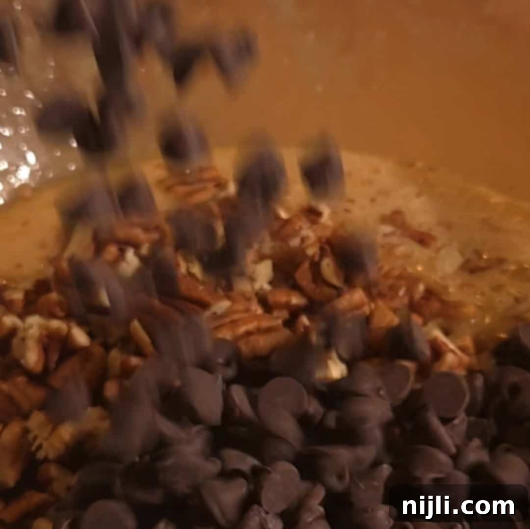 Adding chocolate chips and chopped pecans into the pecan pie filling for chocolate chip pecan pie.